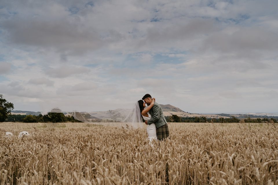 Jessica and Brandon kiss in a scottish field